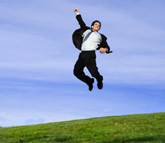 photo shows man in a suit jumping in the air celebrating getting his new job